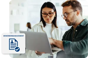 zwei Personen schauen auf den laptop in der hand